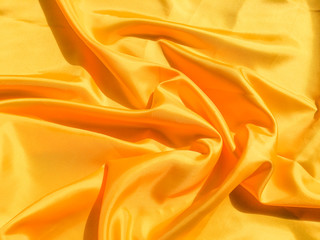 Beautiful yellow silk or satin texture background with copy space for design and artwork