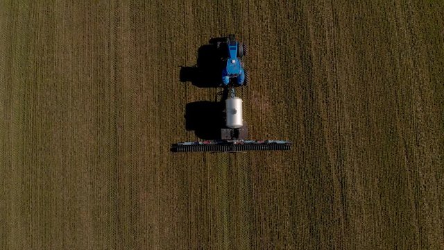 The introduction liquid mineral fertilizers into soil with tractor winter wheat