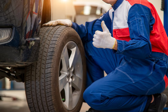 Auto mechanic changing tire outside,Car service.Hands replace tires on wheels.Tire installation concept.