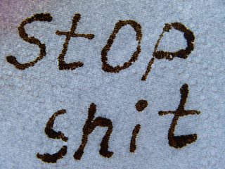 Inscription STOP SHIT with background of white toilet paper. Stay strong in Coronavirus dangerous environment. Pandemic Confrontation Concept