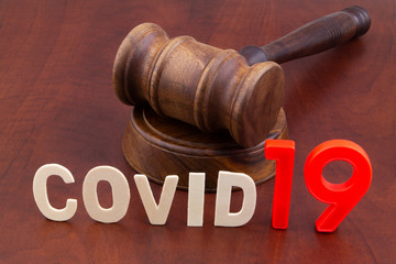 Wooden judge gavel with word covid19. Concept of quarantine and law against covid-19.	