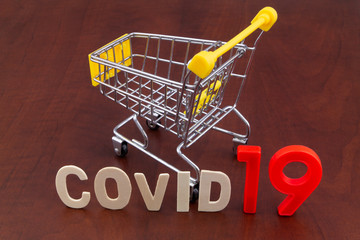 Shopping in coronavirus covid-19 time concept. Shopping cart with word covid19 close up.