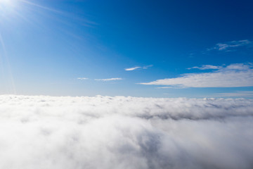 Aerial view White clouds in blue sky. View from drone. Aerial top view cloudscape. Texture of clouds. View from above. Sunrise or sunset over clouds. Panorama clouds