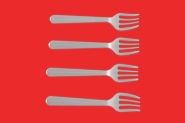four plastic white forks on a red background. isolate. Top view.