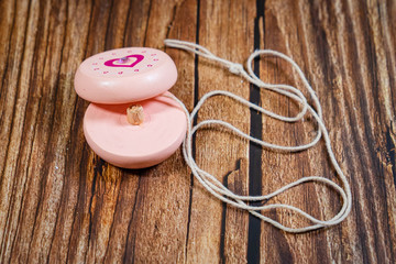 broken pink toy yoyo on wooden background. 