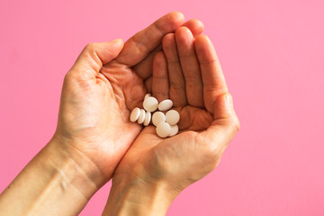 White closeup tablets on a woman's hand. Concept - medicine, recovery of a sick person.