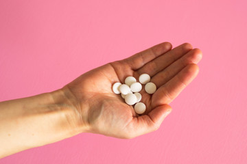 White closeup tablets on a woman's hand. Concept - medicine, recovery of a sick person.