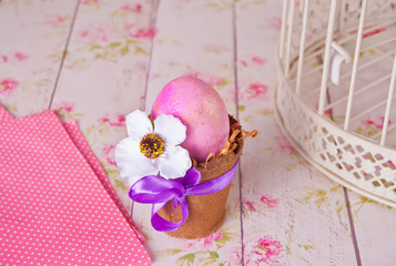Easter pink egg in a pot on the floral background