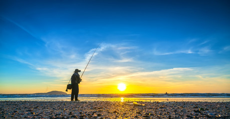 The silhouette of a man fishing in the morning as the sun rises from the horizon, the burden of making a living for the fishermen's hard life in Mui Ne, Vietnam © huythoai
