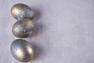 Row of gray Easter eggs on gray wooden background. Copy space.