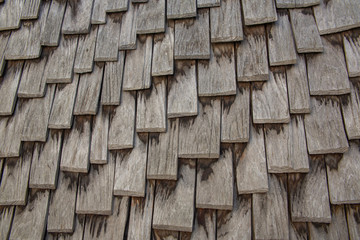 Weathered surface of wooden roof shingles close up, monochrome