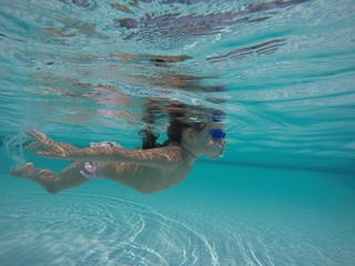 little girl swimming underwater glasses