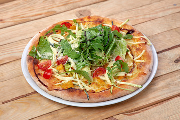 pizza with fresh vegetables on the wooden background