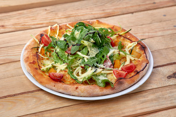 pizza with fresh vegetables on the wooden background