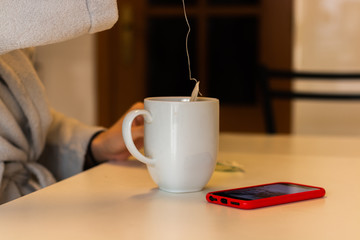 girl with an infusion and the phone on the table