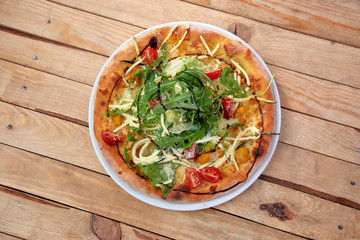 pizza with fresh vegetables on the wooden background