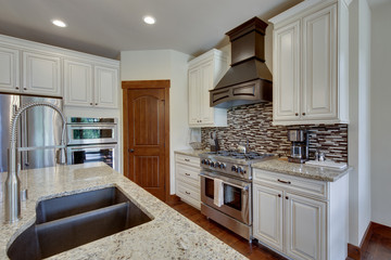 White and brown cabinets luxury huge kitchen interior with amazing details and top noch appliances.