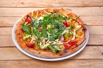 pizza with fresh vegetables on the wooden background