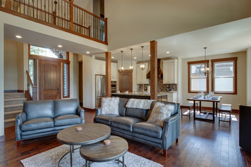 An absolute beautiful luxury living room with huge vaulted  ceiling, fire place, harwood floor, amazing furniture, and lots of windows and doors.