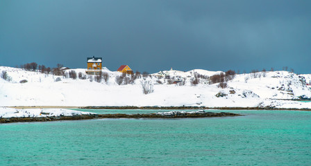 Wooden houses in snowy secenery in Sommaroya Island, Norway