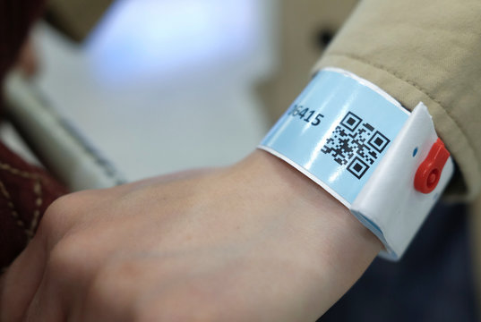 A passenger wears an electronic wrist band handed upon arrival at Hong Kong International Airport, following the novel coronavirus disease (COVID-19) outbreak, Hong Kong