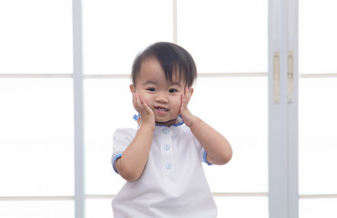 Curiosity Asian toddler lovely girl naughty cheerful play alone in father home office, smiling...