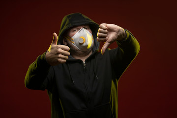 adult man with a beard in a hood and in a protective mask on his face with different emotions,...