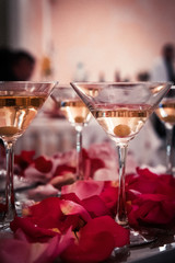 Cocktails in glasses decorated with rose petals.