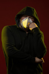 adult man with a beard in a hood and in a protective mask on his face with different emotions,...