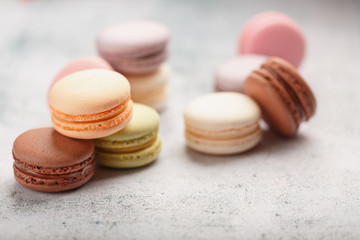 French macaroni cookies of different colors are on the gray table. Still life of confectionery.