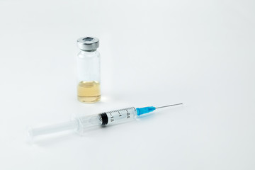 A disposable injection syringe and a drug ampoule on a white background. The place for an inscription
