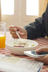 Obraz na płótnie Canvas Man using Cell phone while having breakfast 
