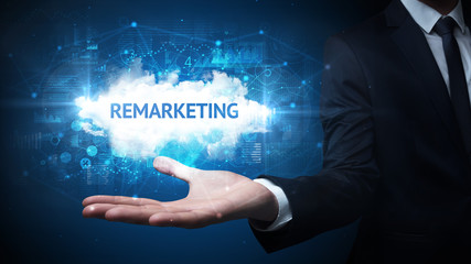 Hand of Businessman holding REMARKETING inscription, successful business concept