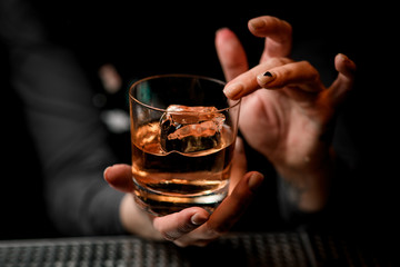 woman holds with one hand glass with alcoholic drink