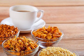Close-up of fried snacks in bowls with cup of tea
