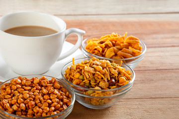 Close-up of fried snacks in bowls with cup of tea
