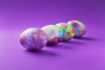 Colored easter eggs on a violet trend