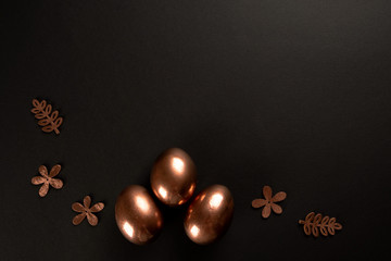 Easter minimal background with gold Easter eggs on black background. Flat lay, Top view, copy space.