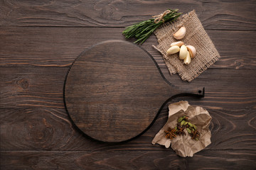 Wooden board and spices on wooden background