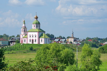 Fototapeta na wymiar Summer view of the Church of Elijah the Prophet and the temple of the Tikhvin icon of the mother of God. City of Suzdal, Vladimir region. Golden ring of Russia