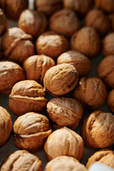 Whole walnuts, vertical close-up shot in harsh sunlight.