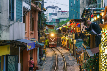 Train passing narrow road in old town in Hanoi