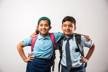 Cheerful Indian school kids in uniform standing isolated over white background