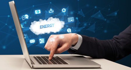 Fototapeta premium Businessman working on laptop with ENERGY inscription, modern technology concept