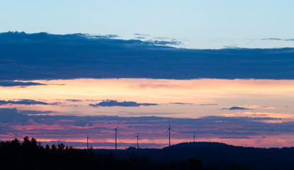 Fototapeta na wymiar Wind turbines on a background of orange sunset sky