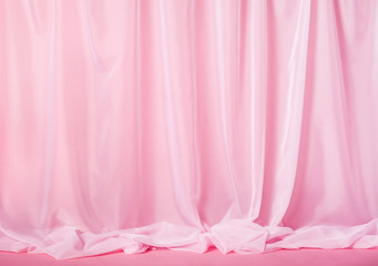 Tender pink silk curtains on pink background