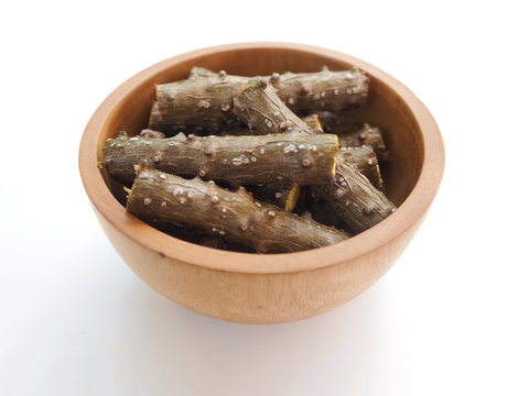 tinospora cordifolia or heart leaved moonseed with wood bowl use as ingredient in hair dandruff shampoo product to soothe itchy, flaky and irritated scalp and dry and is a medicine herb