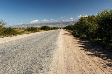 Fototapeta na wymiar asphalt road along the southern shore of Lake Issyk-Kul in Kyrgyzstan.