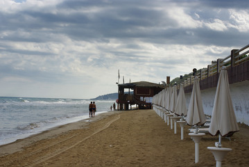 la gente cammina sulla spiaggia lungo il mare