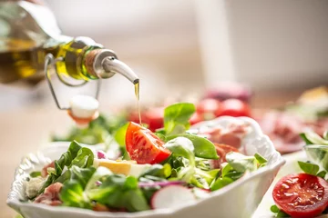Fotobehang Bottle with olive oil pouring into salad © weyo